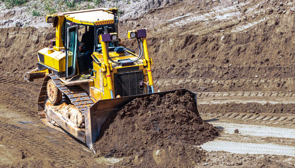 Bulldozer effectuant un nivellement de précision à l'aide d'un système de guidage GPS sur un chantier de construction.